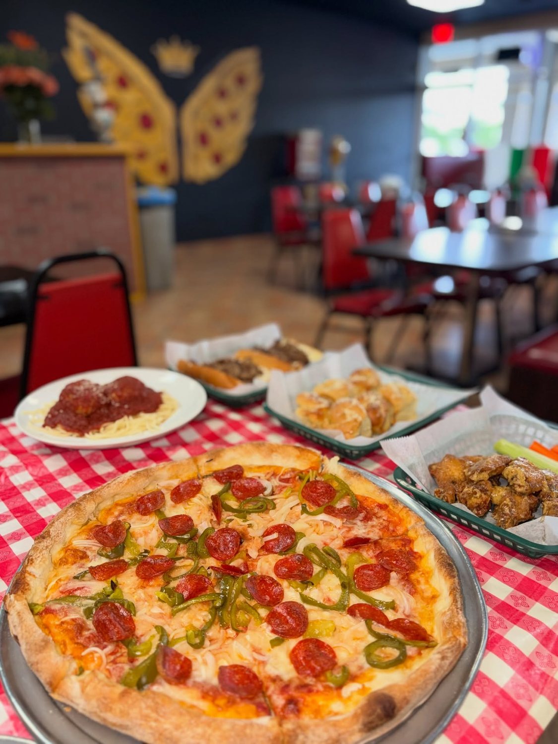 Full table spread of pizza and pasta with the dining room behind